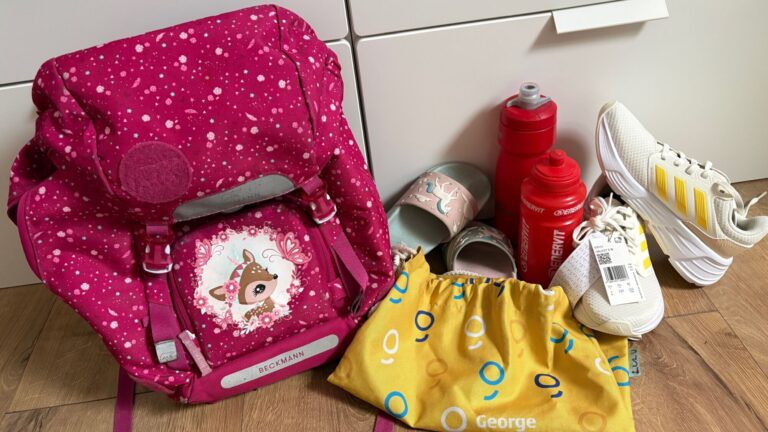 Detské tenisky, papuče a školská taška pri príprave na nový školský rok